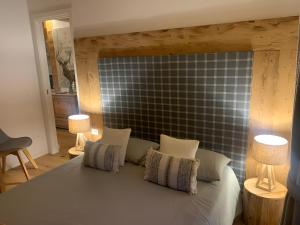 una camera da letto con un letto con due lampade sopra di Chez nous ad Aprica