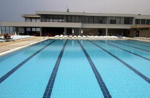 uma grande piscina com cadeiras e um prédio em Varandas do Mar em Arcozelo