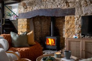 sala de estar con chimenea y sofá en Bourton Newly Remodeled Scandi Chic Authentic Charm & Character, en Bourton on the Water