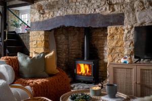 a living room with a fireplace and a couch at Bourton Newly Remodeled Scandi Chic Authentic Charm & Character in Bourton on the Water
