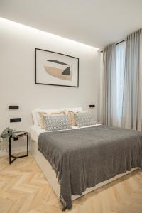 una camera bianca con un grande letto e una finestra di Luxury flat Centro XVI a Madrid