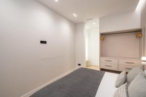a white bedroom with a bed and a dresser at Luxury flat Centro XVI in Madrid