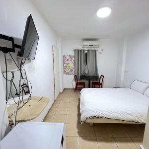 a bedroom with a bed and a flat screen tv at Happy Home in Eilat