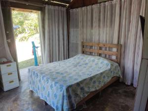 1 dormitorio con 1 cama con edredón azul y ventana en La Loma Camping, en Higüey