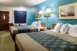 two beds in a hotel room with blue walls at Quality Inn & Suites in Sioux City