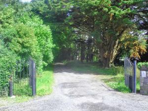 um portão numa estrada de terra ao lado de árvores em Holiday Home Old Court Holiday Home-2 by Interhome em Terryglass