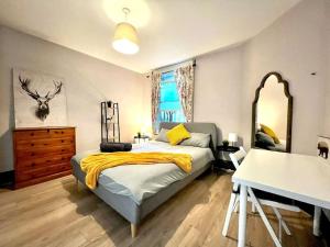 um quarto com uma cama, uma cómoda e um espelho em Spacious 2-Bed House 20 mins from Central London em Londres