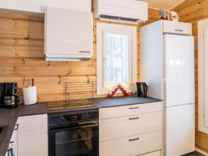eine Küche mit weißen Geräten und Holzwänden in der Unterkunft Holiday Home Kianta by Interhome in Sotkamo