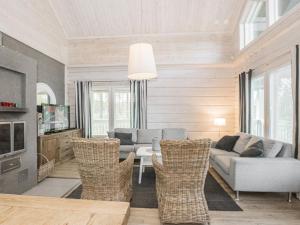 sala de estar con sofá, mesa y sillas en Holiday Home Sinisen tien helmi by Interhome, en Kannonkoski