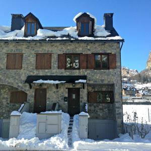 a stone house with snow on top of it at Bonita casa de montaña en el Pirineo Central in Escarrilla