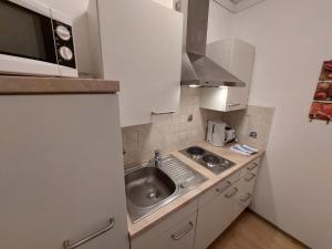 a small kitchen with a sink and a microwave at Apartment Landhaus St- Georg-4 by Interhome in Bad Gastein