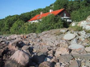 una gran pila de rocas delante de una casa en Holiday Home Asgot - 15m from the sea in Bornholm by Interhome en Hasle