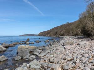 a large group of rocks on the shore of a body of water at Holiday Home Asgot - 15m from the sea in Bornholm by Interhome in Hasle