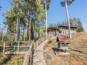 um caminho de madeira que leva a uma casa na floresta em Holiday Home Sinituuli by Interhome em Savitaipale