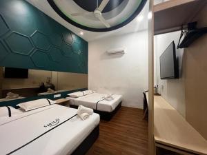 a room with two beds and a flat screen tv at Smile Hotel Wangsa Maju in Kuala Lumpur