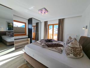 una camera con letto, divano e specchio di Apartment Alpina-3 by Interhome a Finkenberg