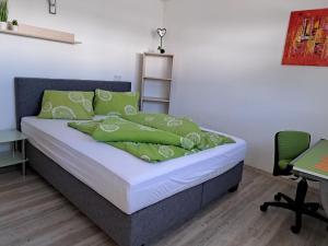 una camera da letto con un letto con cuscini verdi di Apartment Alpina-3 by Interhome a Finkenberg