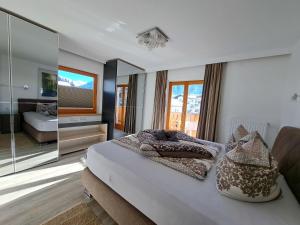 Schlafzimmer mit einem Bett und einem Spiegel in der Unterkunft Apartment Alpina-3 by Interhome in Finkenberg