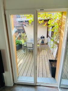 una porta scorrevole in vetro che si apre su un patio con tavolo di Joli 2 pièces et terrasse vue sur les toits en zone piétonne a Haguenau