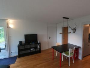 uma sala de estar com uma mesa e uma televisão em Apartment Chilis Ferienresidenz by Interhome em Aeschi