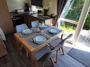 a dining room table with plates and glasses on it at Holiday Home am Waldsee by Interhome in Wemding