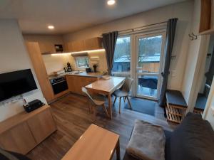 a living room with a table and a kitchen with a window at Holiday Home am Waldsee by Interhome in Wemding