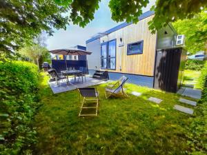 a house with a yard with chairs and a table at Holiday Home am Waldsee by Interhome in Wemding