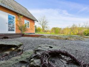 dom z kupą kamieni przed nim w obiekcie Holiday Home Adrienne - 6-4km from the sea in Bornholm by Interhome w mieście Åkirkeby
