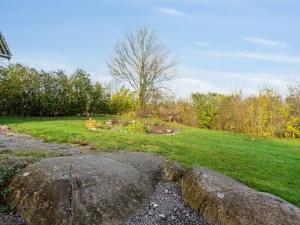 a field with two large rocks in the grass at Holiday Home Adrienne - 6-4km from the sea in Bornholm by Interhome in Åkirkeby