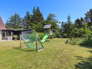 two swings in a yard with a gazebo at Holiday Home Lavrans - 2-5km from the sea in Western Jutland by Interhome in Henne Strand