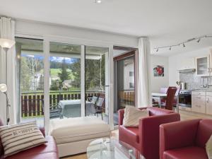 a living room with red furniture and a balcony at Apartment Auarara by Interhome in Lenzerheide