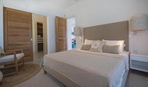 a bedroom with a large bed and a chair at PentHouse sur mer - Blue Alizée in Blue Bay