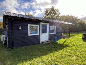 een kleine hut met een deur op een grasveld bij Holiday Home Janna - 1-4km from the sea in Sealand by Interhome in Vig