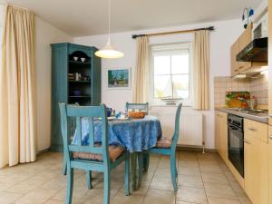 une cuisine avec une table et des chaises bleues ainsi qu'une fenêtre dans l'établissement Apartment Eickhus Blaue Wohnung by Interhome, à Zinnowitz