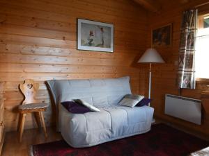 ein Wohnzimmer mit einem Sofa in einem Holzzimmer in der Unterkunft Chalet Kil-Ukru by Interhome in Ovronnaz