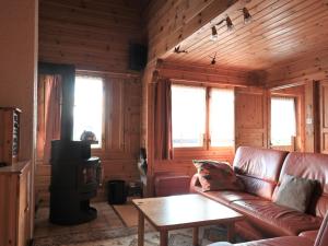 ein Wohnzimmer mit einem Ledersofa und einem Tisch in der Unterkunft Chalet Kil-Ukru by Interhome in Ovronnaz