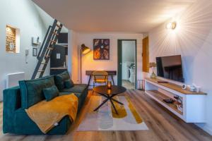 a living room with a green couch and a table at Le GreenStation-Gare-Hortillonnages-Centre Ville in Amiens