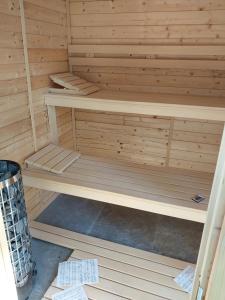 a wooden sauna with wooden shelves in a room at Strefa ciszy Lubomin 