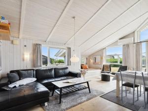 a living room with a black couch and a table at Holiday Home Sira - 350m from the sea in Funen by Interhome in Spodsbjerg