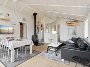 a living room with a black couch and a table at Holiday Home Sira - 350m from the sea in Funen by Interhome in Spodsbjerg