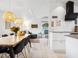 a kitchen and living room with a wooden table and chairs at Holiday Home Felis - all inclusive - 75m from the sea by Interhome in Martofte