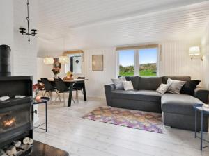 a living room with a couch and a fireplace at Holiday Home Felis - all inclusive - 75m from the sea by Interhome in Martofte