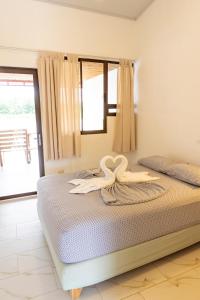 Un dormitorio con una cama con dos cisnes. en Hotel Pura Natura Riverside Tortuguero, en Tortuguero