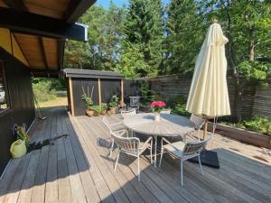 een patio met een tafel en een parasol bij Holiday Home Annemone - from the sea in Sealand by Interhome in Rørvig