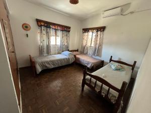 Kleines Zimmer mit 2 Betten und einem Tisch in der Unterkunft María Chusena alojamiento 1 in Fray Bentos
