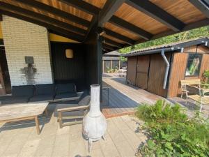 een patio met een bank en een vaas erop bij Holiday Home Annemone - from the sea in Sealand by Interhome in Rørvig