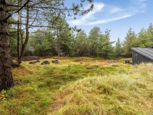 a group of animals grazing in a field next to a barn at Holiday Home Emila - 2-2km from the sea in Western Jutland by Interhome in Bolilmark
