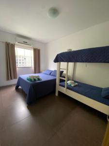 a bedroom with two bunk beds and a window at Pousada da Mel - Canasvieiras Floripa in Florianópolis