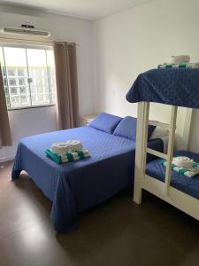 Pousada da Mel - Canasvieiras Floripa في فلوريانوبوليس: غرفة نوم بسريرين بطابقين مع ملاءات زرقاء