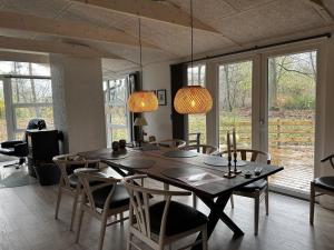 comedor con mesa, sillas y ventanas en Holiday Home Gretl in Western Jutland by Interhome en Arrild
